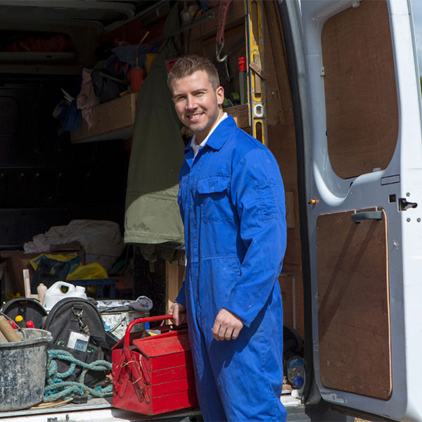man standing beside a van smiling